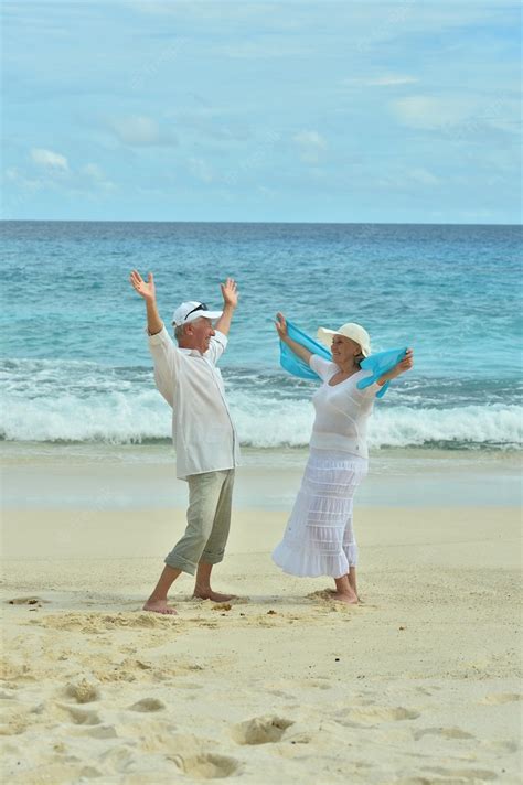 Premium Photo | Portrait of happy elderly couple resting on tropical beach