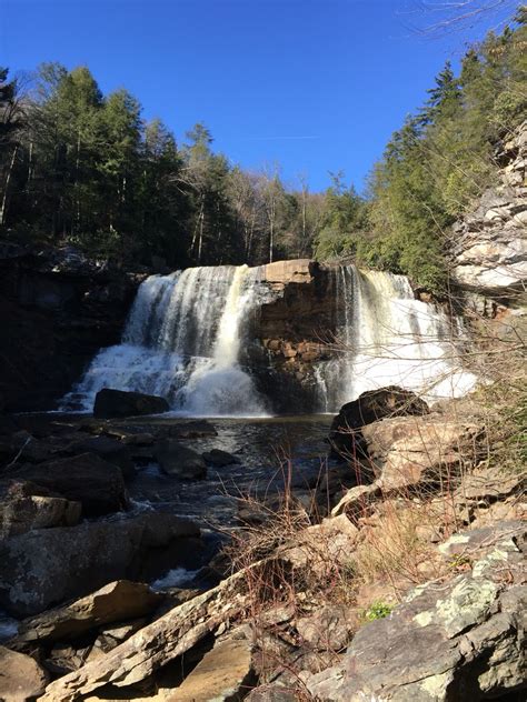 a large waterfall with lots of water coming out of it's sides in the woods