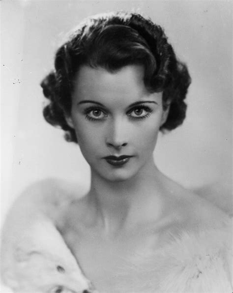 an old black and white photo of a woman with a fur stole around her neck