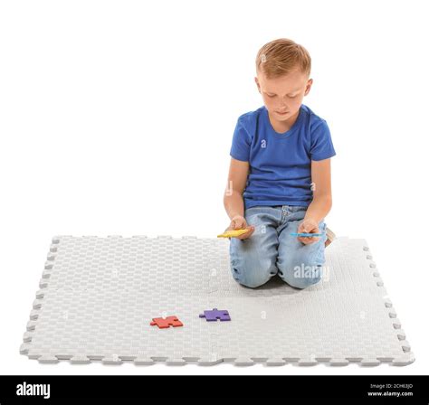 Little boy with autistic disorder doing puzzle on white background Stock Photo - Alamy