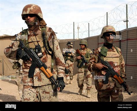 Iraqi Army soldiers load their weapons and conduct a final gear ...