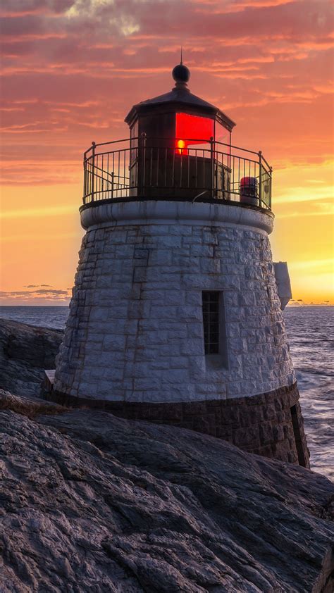 Castle Hill Lighthouse in orange sunset, Narragansett Bay in Newport, Rhode Island, USA ...