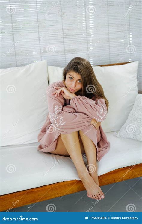 Childish Woman in Pink Dress Sitting with Legs Up on a Sofa, Looking Up Stock Photo - Image of ...