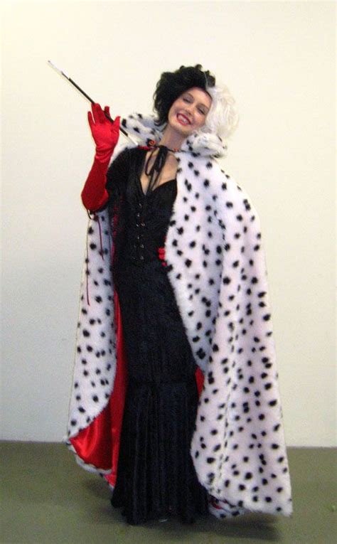 a woman dressed in black and white polka dots holding a red umbrella while standing next to a wall