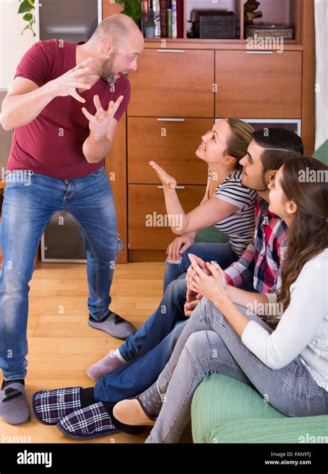 Happy american adults playing charades indoor and laughing Stock Photo - Alamy