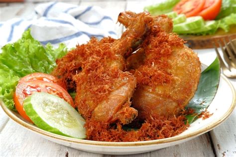 Premium Photo | Ayam goreng serundeng, fried chicken sprinkled with grated coconut with curry ...