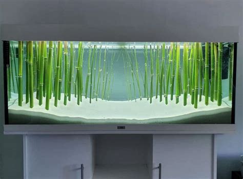 a flat screen tv mounted to the side of a wall with grass growing on it