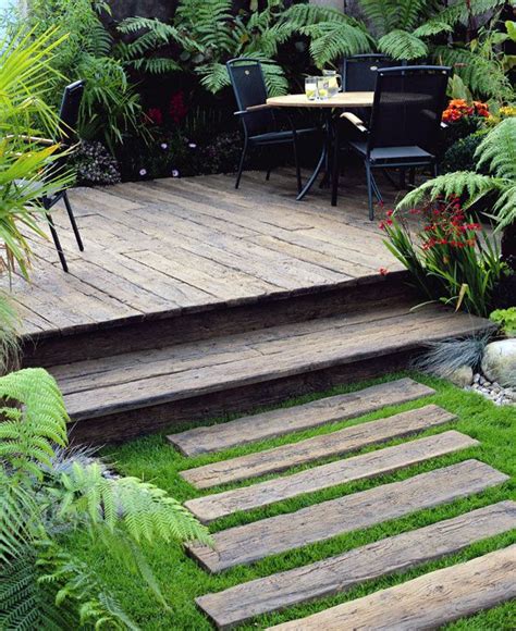 a wooden deck surrounded by lush green plants