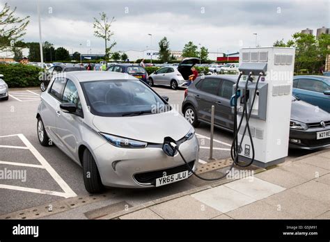 Electric Renault car charging at a recharging point in the car park of ...