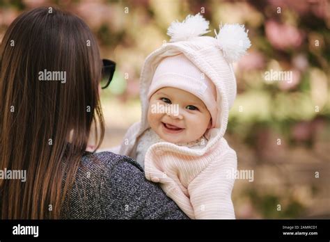 Portrait of cute little baby girl outside with mom. Beautiful girl smile. Five month baby. Happy ...