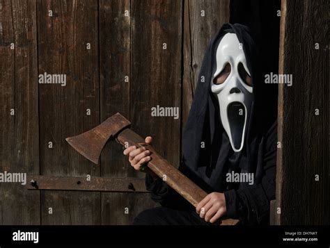 Man in scary "scream" mask holds axe. Mask of grim reaper. Carnival ...