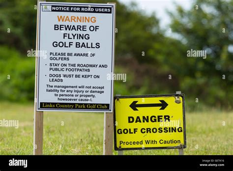 Warning signs where a road crosses a golf course Stock Photo - Alamy