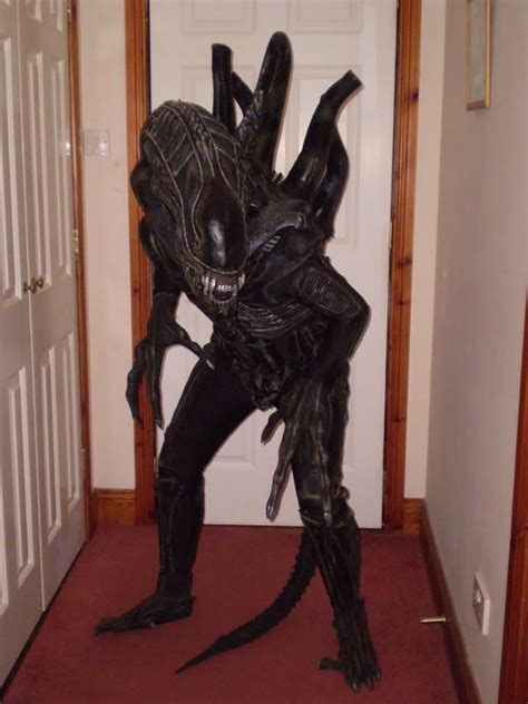 a man dressed as an alien standing in front of a door