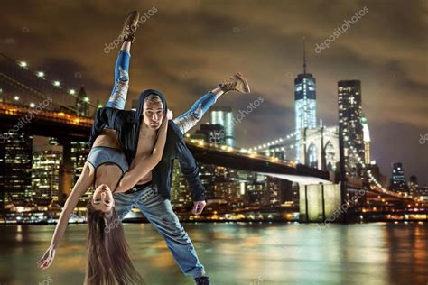 Young hip hop couple dancing, over urban background — Stock Photo © konradbak #101745976