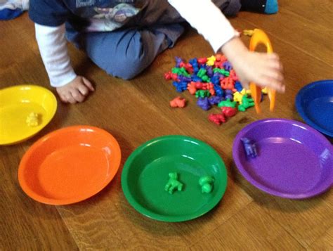 Sorting colours with tweezers to help fine motor skills.