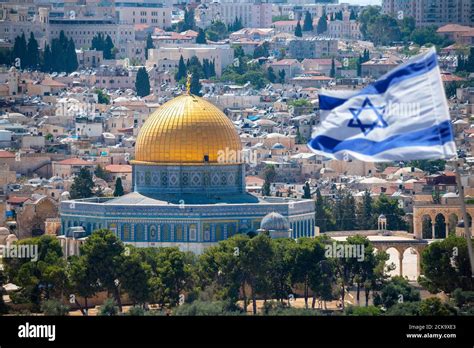 An Israeli flag blows in the wind from the mount of olives overlooking ...