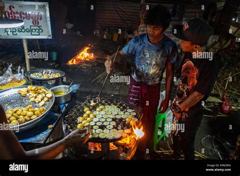 Man cooking at a street-food stall near the Sanda Muni Pagoda during the Thadingyut Festival ...