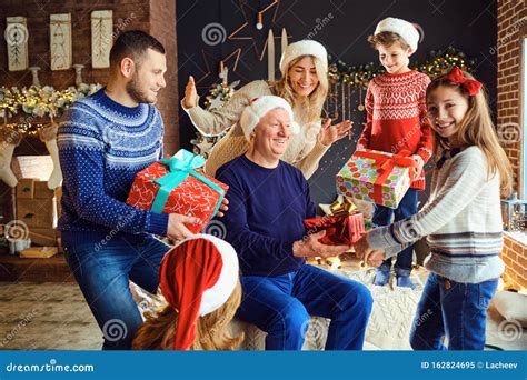 A Big Family in a Room Gives Gifts at Christmas. Stock Image - Image of ...