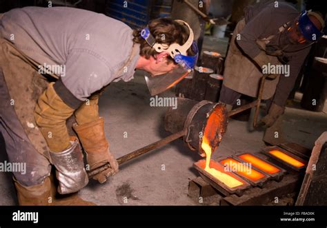 Foundry worker pouring hot metal into cast Stock Photo - Alamy