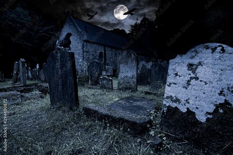 old graveyard with ancient tombstones grave stone and old church front ...