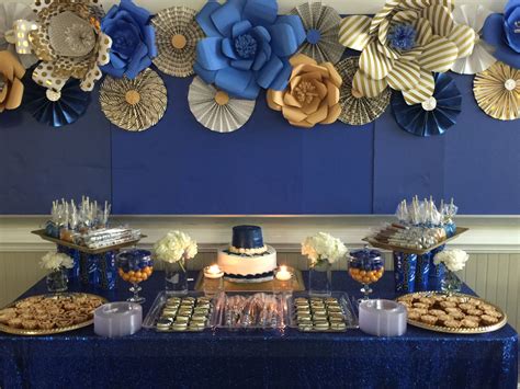 Royal blue and gold dessert table with paper flowers and fan as backdrop | Gold dessert table ...