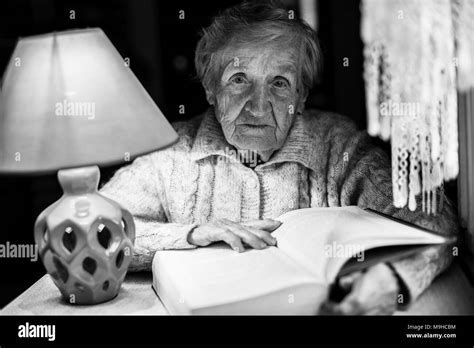 Old woman with glasses reads a book Black and White Stock Photos ...