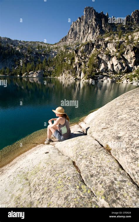 Woman sitting on the shore of Lake Viviane, Enchantment lakes, Alpine Lakes Wilderness ...