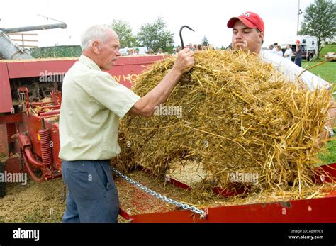 Local farmers demonstrate hay bailing techniques in a circa 1920 saw mill festival Goodells Park ...