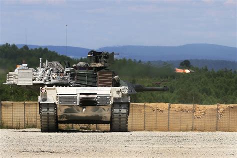 A U.S. Army M1A1 Abrams tank engages targets as a tube-launched ...