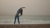 Young Fitness Woman In Sports Clothing Making Exercises On The Beach In ...