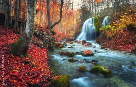 Autumn forest with waterfall at mountain river at sunset. Colorful ...