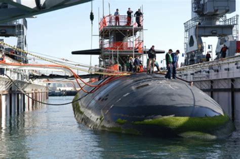 The USS Helena (SSN 725) is guided and pulled by mooring lines into a floating dry dock.