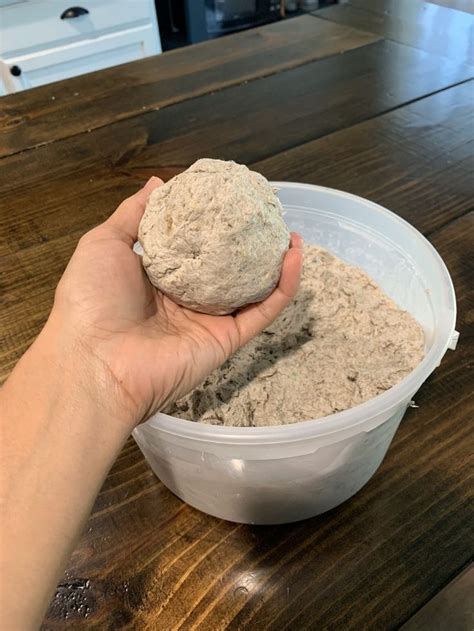 a person is holding something in a bowl on a table with a wood floor ...