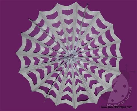 a paper spider with eyes on it's web