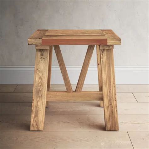 a wooden stool sitting on top of a hard wood floor next to a white wall