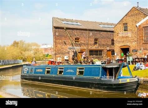 Canal narrowboat passing the Middleport pottery factory on the Trent and Mersey canal as it ...