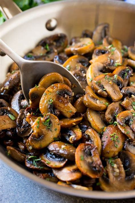 A pan of sauteed mushrooms in garlic butter with a serving spoon in it. | Mushroom recipes ...