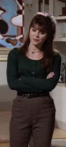 a woman standing in front of a counter with her arms crossed