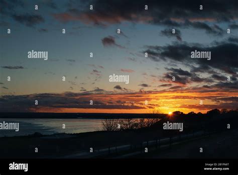 Cloudy sunset over Pegwell Bay, Kent. The sun can be seen with sun rays ...