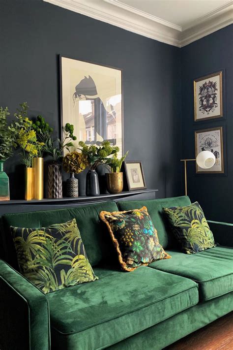 a living room with green velvet couches and potted plants on the shelf ...