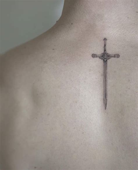 Micro-realistic sword tattoo on the upper back.