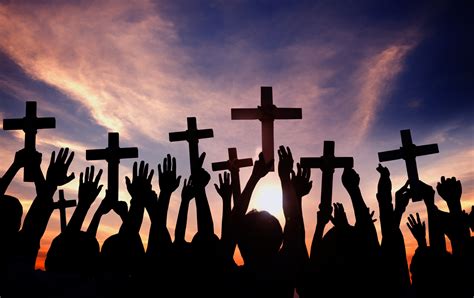 Group of People Holding Cross and Praying in Back Lit - ChristNOW