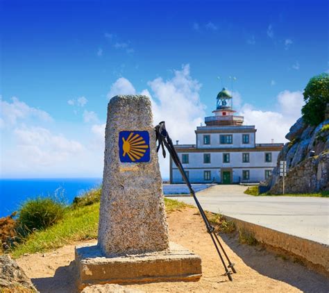 Premium Photo | Saint james way sign and lighthouse of finisterre