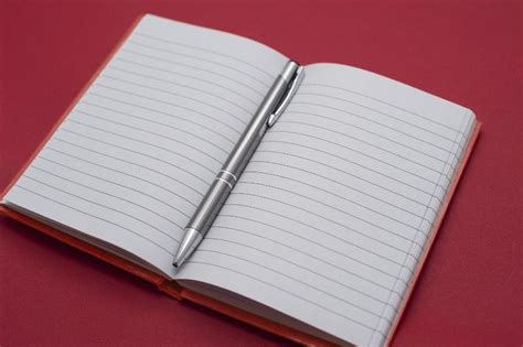 Free image of Open notebook with a ballpoint pen in the center