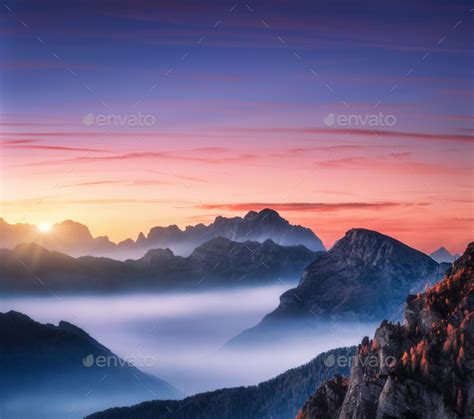 Mountains in fog at beautiful sunset in autumn Stock Photo by den-belitsky