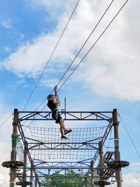 Premium Photo | A teenager in sports equipment descends on a suspended ...