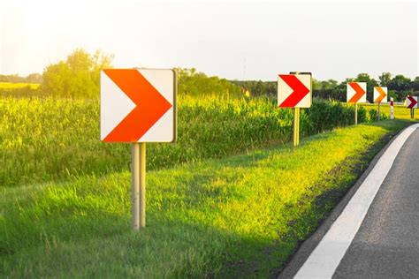 Premium Photo | Road signs in european style warn of a sharp turn on a ...