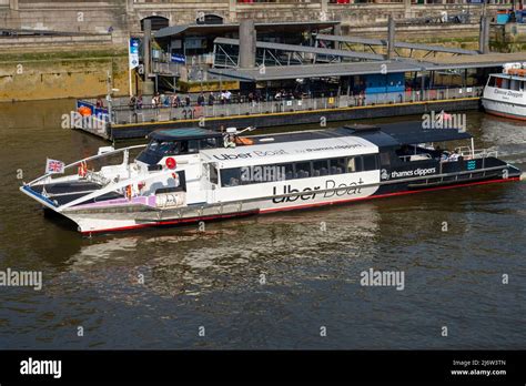 Uber Boat by Thames Clippers river bus on River Thames, London, UK. Moon Clipper leaving ...