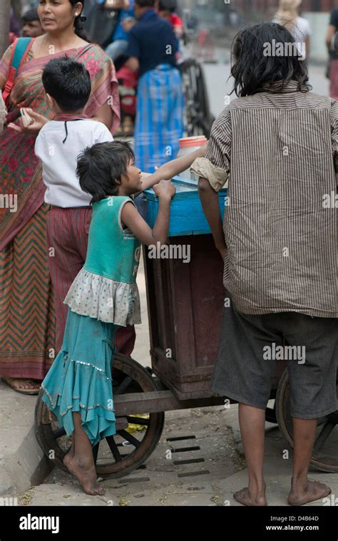 A child beggar buys sweets from a street vendor In Kolkata, India Stock Photo - Alamy
