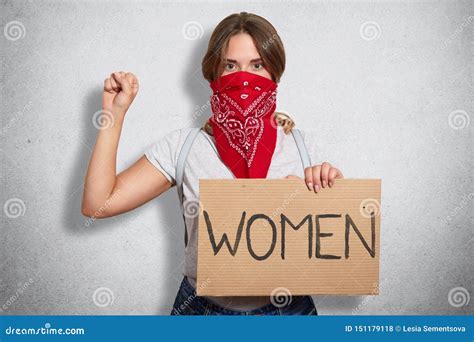 Image of Serious Bossy Militant Young Feminist Raising Arm, Showing Fist, Holding Sign in One ...